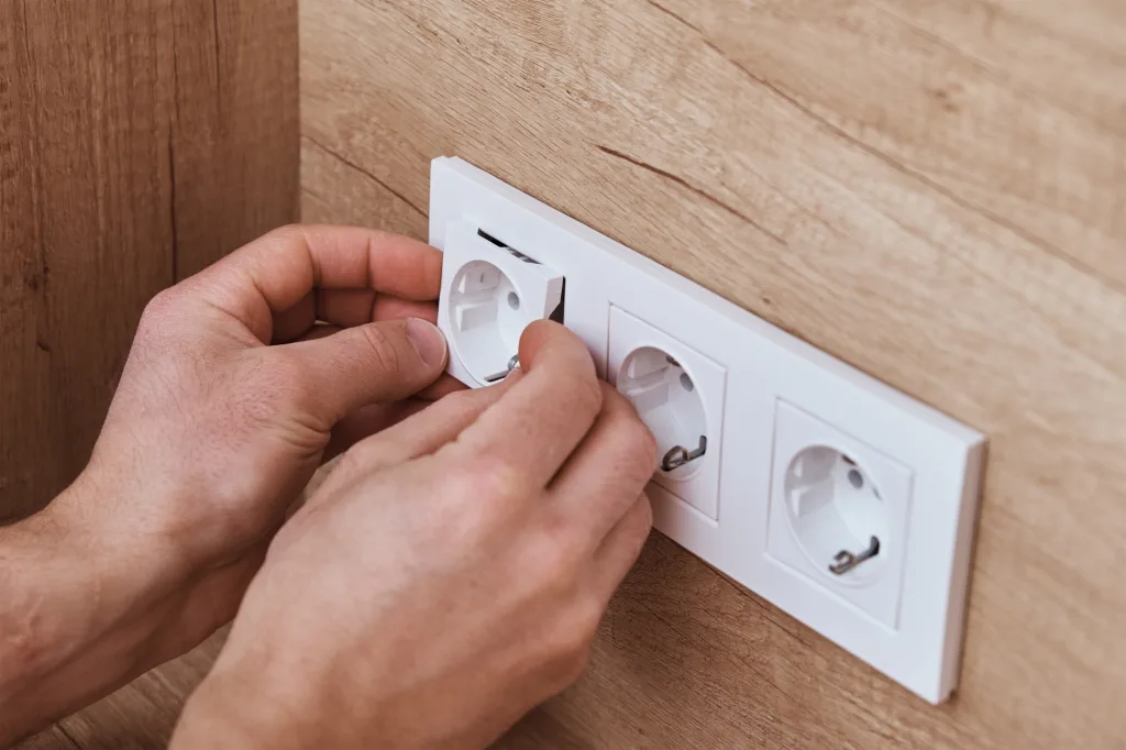 Electrician installing socket in the kitchen