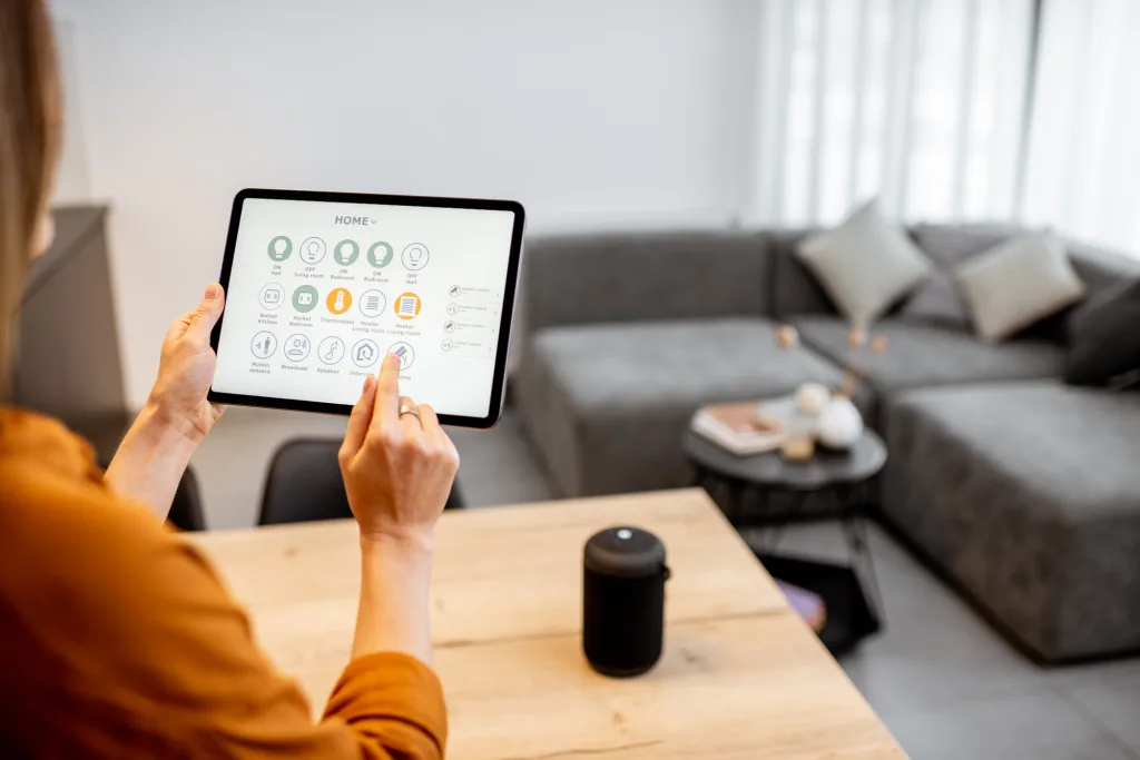 Woman controlling smart devices with a digital tablet at home